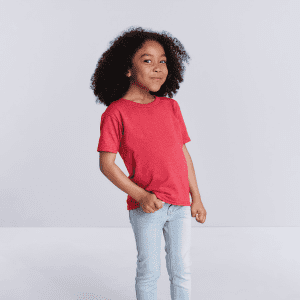 A red toddler t-shirt displayed on a child with curly hair, paired with light blue jeans. It features a logo.