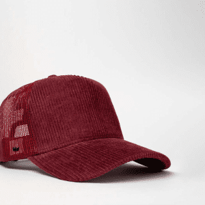 A burgundy cord trucker snapback cap featuring a mesh back and a logo.