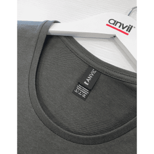 A black T-shirt with a round neck, featuring a label and a hanger with a logo.
