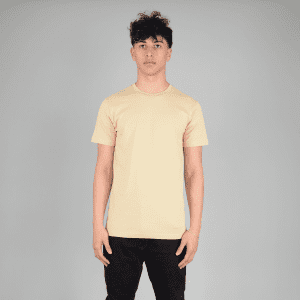 A plain peach T-shirt featuring a crew neck and short sleeves, displayed on a model against a grey background.