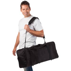 A man carrying a large black duffle bag over his shoulder, featuring multiple compartments and a logo.
