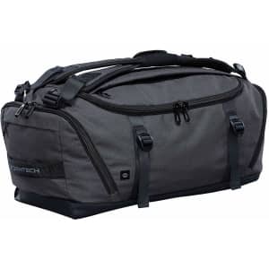 A grey duffle bag with multiple zippered compartments and carry handles. It features a logo and a sleek design.