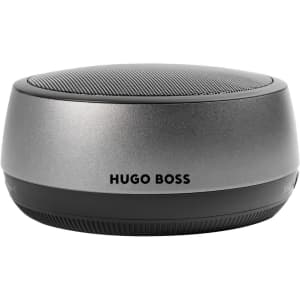 A silver speaker with a black base and a mesh top, featuring a logo on the side.