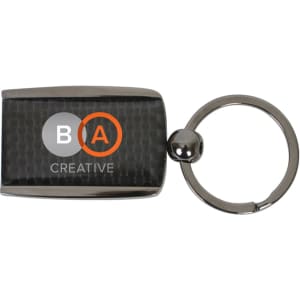 A carbon fibre keychain featuring a rectangular design and a metallic silver ring. It includes a logo.