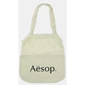 A light cream cotton shopping tote with a logo on the front and two handles.