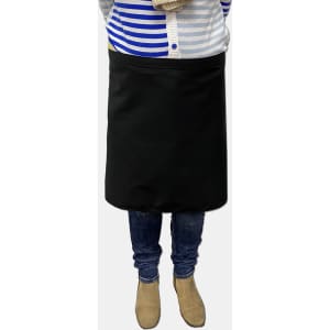 A black waist apron worn by a person, paired with blue jeans and beige boots, with a striped top above.