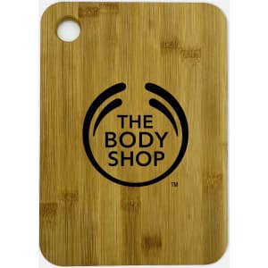 A large bamboo cutting board featuring a round hole and a logo in black.