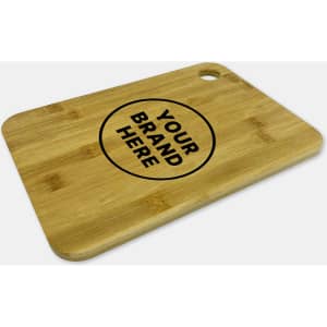 A large bamboo cutting board with a round logo in the centre and a hole for easy hanging.