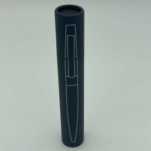 A metal pen presented in a sleek black cylindrical case with a logo.