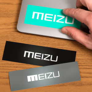Three glossy paper stickers in black, grey, and teal, featuring placeholder branding.