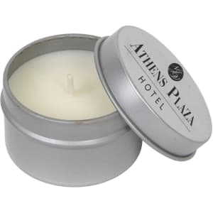 A vanilla scented candle in a silver tin container with an open lid. Features branding on the lid.