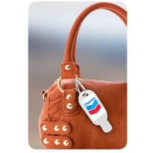 A 30mL hand sanitiser with a carabiner, featuring a logo, attached to a brown handbag.