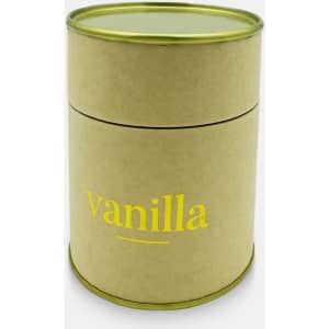 A medium cylindrical candle in a natural cardboard container with a green lid, labelled 'vanilla' in yellow lettering.