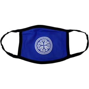 A blue cotton face mask with a black trim and a circular decorative design in the centre.