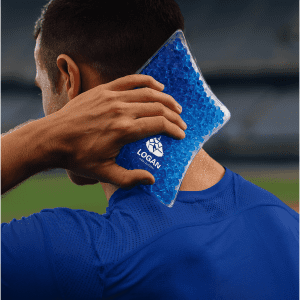 A blue Caviar Bead Cooling Pack held against the neck of a person wearing a blue athletic shirt. The pack has a logo.