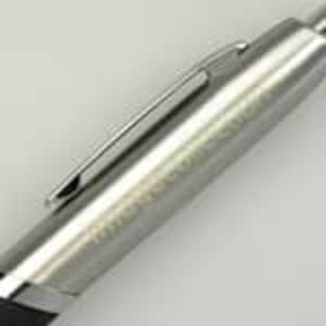 A silver pen with a black grip and a metal clip, featuring branding on the barrel.