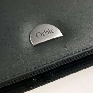 A black leather wallet featuring a silver logo emblem. The wallet has a sleek design with a zippered closure.