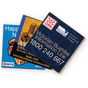 Three fridge magnets featuring colourful designs and logos, including a blue cartoonish character and text details.