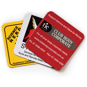 A set of three square fridge magnets in yellow, red, and grey, featuring logos and various designs.