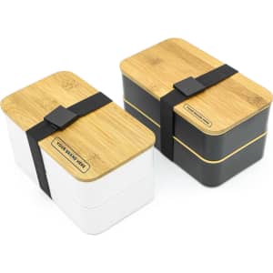 A two-layer lunch box in white and black with bamboo lids and a black strap. Features a logo on the side.
