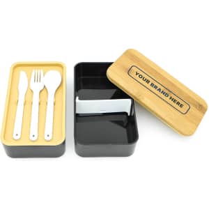 A two-layer lunch box featuring a black and bamboo design, containing cutlery including a knife, fork, and spoon.
