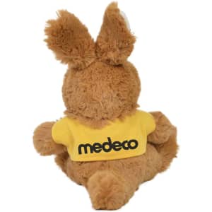 A soft, brown plush kangaroo with large ears and a yellow shirt featuring a logo on the back.