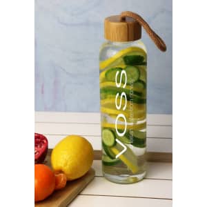A drink bottle with a clear body, bamboo lid, and filled with sliced cucumber, lemon, and pomegranate. It features a logo.
