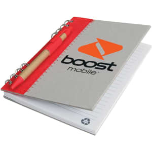A recycled journal book with a grey cover, red accents, and a pen attached. The journal includes lined pages and a logo.