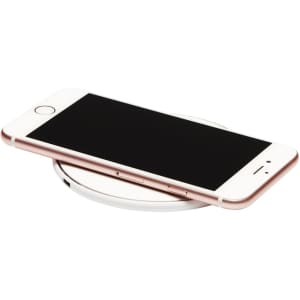 A round wireless charging dock in white, with a smartphone resting on top. The phone has a rose gold edge.