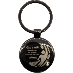 A gunmetal keychain featuring a circular shape and a design, with a branded logo.