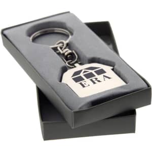 A silver keychain in a tag shape, presented in a grey box with a soft interior, featuring a logo.