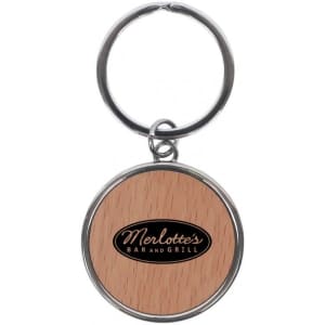 A round keychain featuring a wooden design and a logo in the centre, attached to a metal keyring.