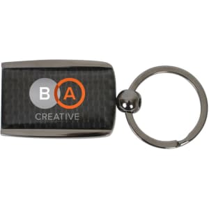 A carbon fibre keychain with a metallic finish and a round keyring attachment. Features a logo on the front.