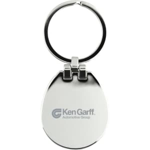 A silver keychain with a rounded shape and a ring, featuring a logo on one side.