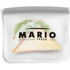A PEVA reusable food storage bag in clear, featuring a sandwich inside and a logo on the front.