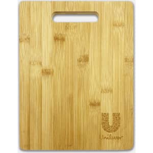 A bamboo chopping board with a handle, featuring a subtle logo in the corner. It has a natural wood finish.