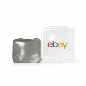 A grey jelly cube sensory toy next to a transparent container featuring a logo.