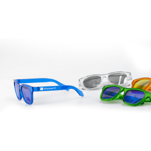A pair of blue sunglasses alongside green, orange, and clear sunglasses, featuring a logo on the blue pair.