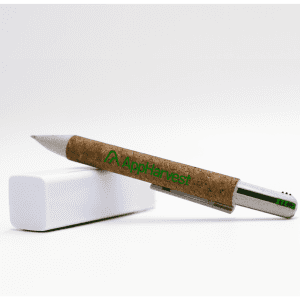 A cork pen with a silver clip, resting on a white block, featuring branding on the cork barrel.