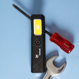 A rechargeable work light in black with a yellow light panel, alongside a red screwdriver and a silver wrench.