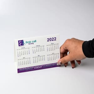 A desk calendar displaying the months from January to May 2022, featuring a white and purple design with a logo.