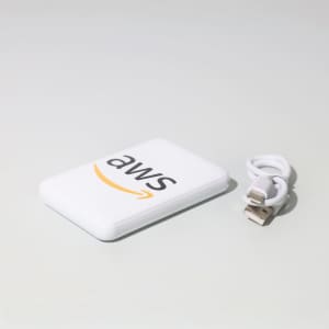 A white powerbank with a logo and a small USB cable beside it.