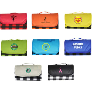 A variety of picnic blankets in bright colours, featuring different logos and a black and white checkered design.
