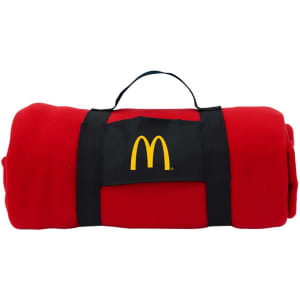 A rolled red blanket secured with a black strap featuring a logo. The blanket is compact and portable.