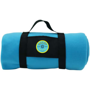A rolled-up blue fleece blanket is secured with a black strap and features a circular logo.
