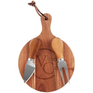 A round wooden cheeseboard with a branded logo, featuring a cheese knife and fork with wooden handles.