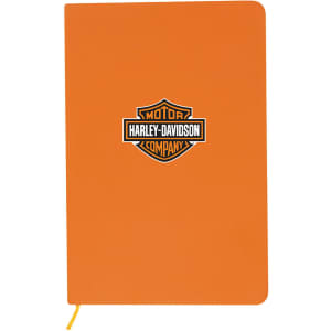 An orange A5 notebook with a logo on the front and a yellow elastic closure.