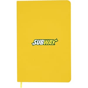 A yellow A5 notebook features an emblem and has a ribbon bookmark. It has a smooth cover and rounded edges.