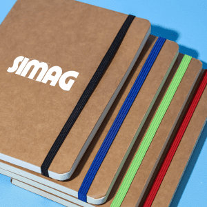 A stack of brown notebooks with colourful elastic bands in blue, green, and red, featuring a logo on the front.
