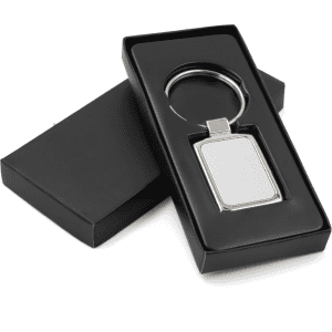 A rectangular metal keychain in a sleek black box, featuring a shiny silver finish and a simple design.